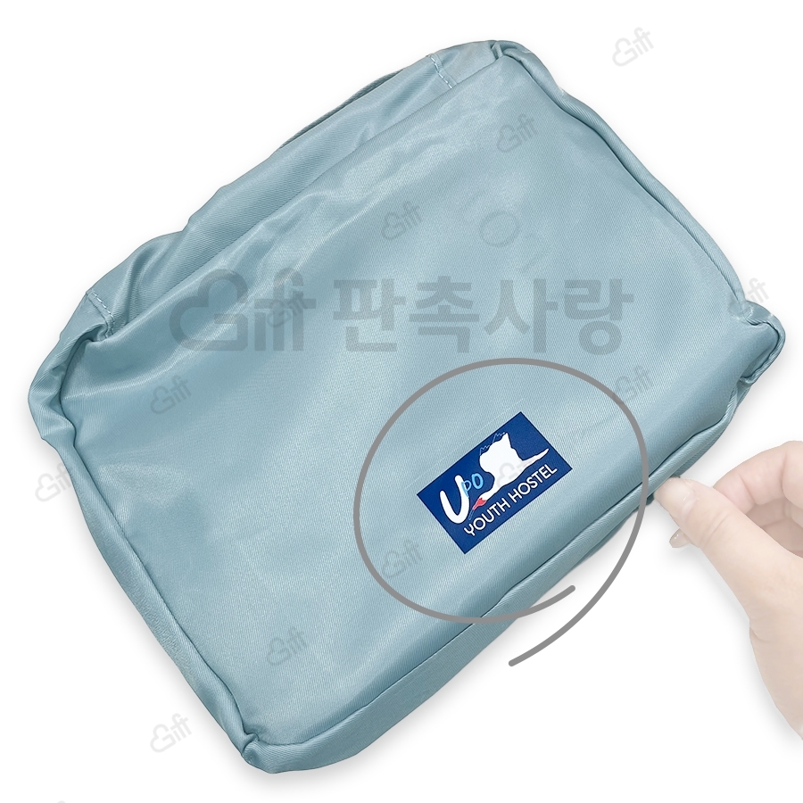 청록색 여행용 파우치에 유스호스텔 로고를 넣은 공개 제작 사진